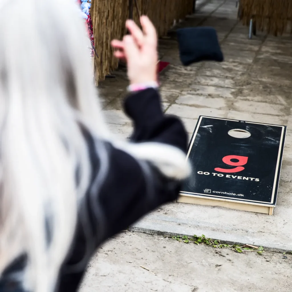 Kvinde dyster i Cornhole som en hold aktivitet til teambuilding med arbejdspladsen