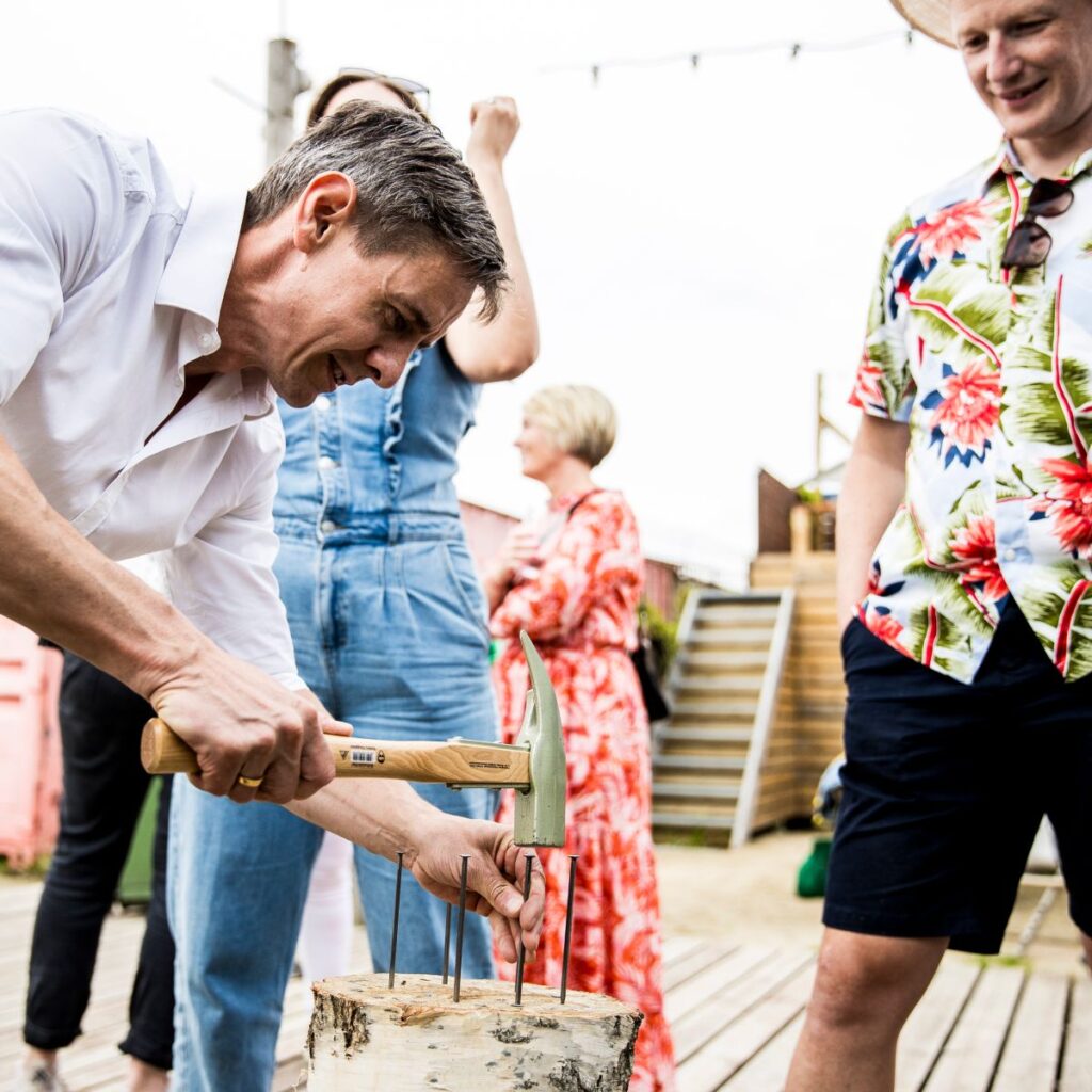 Sommerfest hvor gæster dyster i aktiviteten Slå søm.