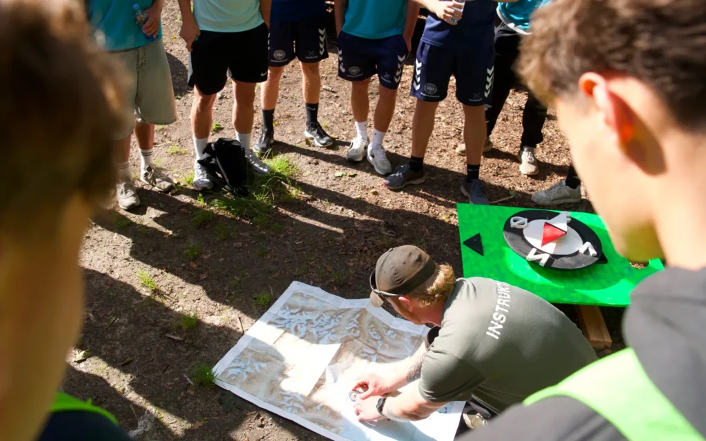 find vej i naturen - lær kompas og kort til teambuilding dag i naturen Learn how to use a compass and a map and find your way without electronic aids. Outdoor team-building day focused on camaraderie and nature