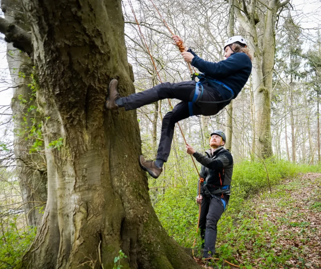 udendørs teambuilding - klatring og rapelling Instructor teaches climbing and rappelling for an outdoor team-building event in nature