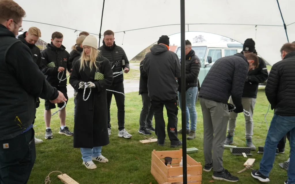 udendørs teambuilding - vildmarks undervisning og natur teambuilding Guests tie knots and learn how to make various knots with an instructor during an outdoor team-building day