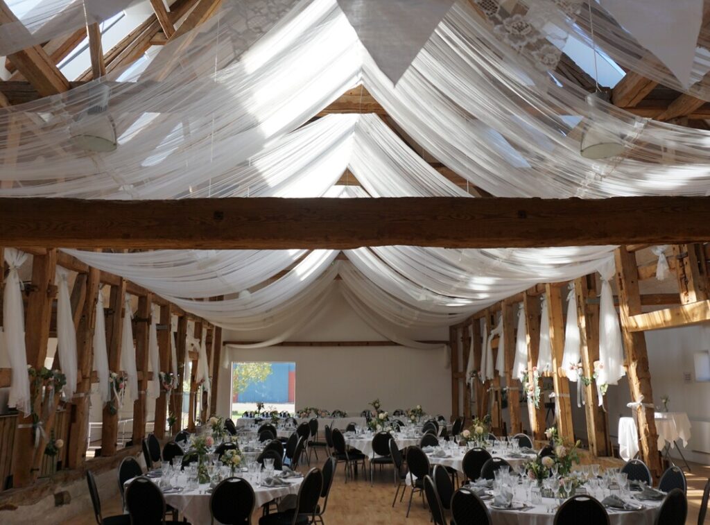 Draperet loft og runde borde. temafest og Winter Wonderland-julefrokost på Vognserup Gods