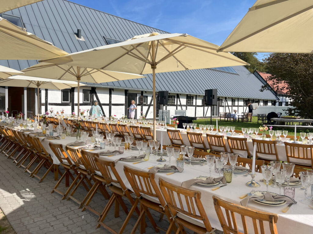 Udendørs langbord under parasoller til sommerfest og company day på Vognserup Gods